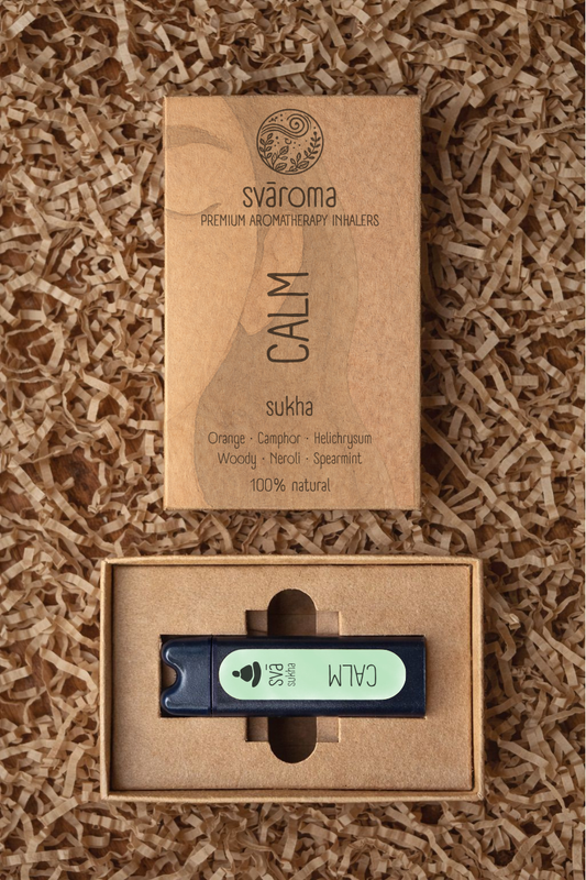 Svaroma Calm aromatherapy inhaler in eco-friendly brown box packaging with inhaler device inside, designed to promote relaxation. Blend includes Camphor, Orange, Helichrysum Woody, Neroli, and Spearmint.