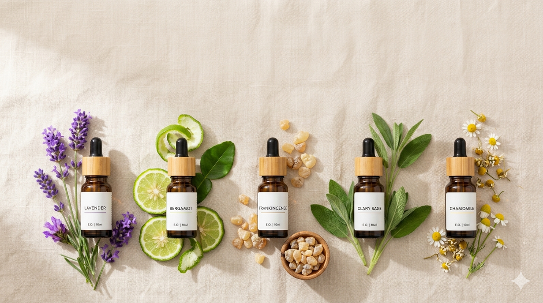Five essential oils for anxiety including lavender, bergamot, frankincense, clary sage, and chamomile displayed in amber glass bottles with matching herbs and flowers on a soft neutral background.